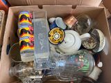 a box full of empty glass bottles and a teapot