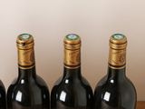 four bottles of wine are lined up on a wooden table