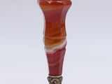 a red and orange vase sitting on a white surface