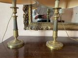deux bougies posées sur une table, avec un miroir en arrière-plan
