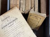 une boîte pleine de vieux livres posée sur le sol