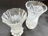 two clear glass vases sitting on a black surface