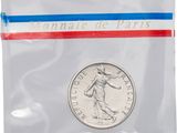 a coin in a plastic bag with a red, white and blue ribbon