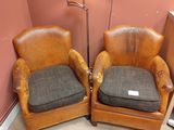 deux fauteuils en cuir marron placés l'un à côté de l'autre dans une pièce