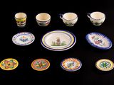many plates and cups on a table with a black background
