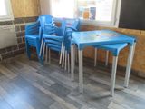 plusieurs chaises bleues et une table dans une pièce dotée d'une fenêtre
