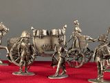 five figurines of a horse drawn carriage on a red surface