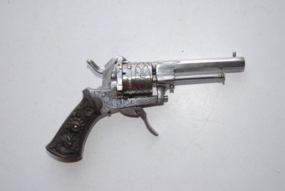 an old silver revolver with a wooden handle on a white surface