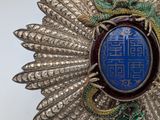 a close up of a broochle with a dragon on it