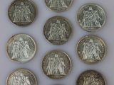 six pièces de monnaie britanniques différentes empilées les unes sur les autres sur une surface blanche
