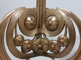 a metal sculpture of a face on a stand