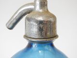 a blue glass bottle with a metal cap on it