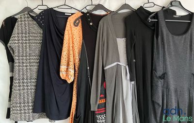 a lot of clothes hanging on a rack in a room