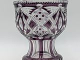 a purple glass vase with a design on it