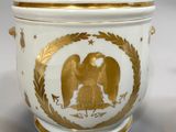 an image of a white and gold vase with an eagle on it