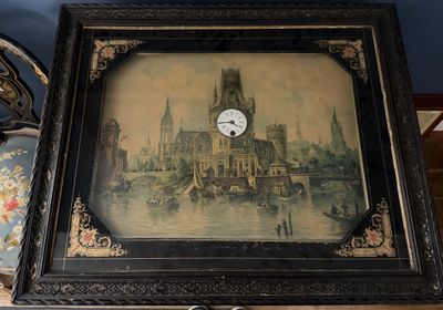 une photo représentant une horloge dans un cadre, posée sur une table