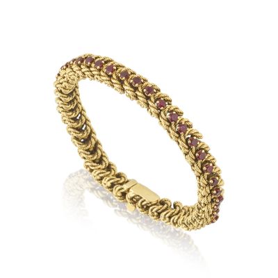 une bague en or jaune sertie de saphirs roses sur fond blanc