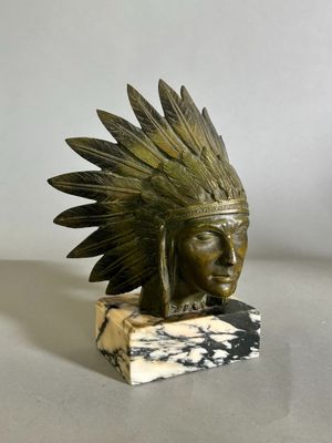 statue représentant la tête d'un Amérindien ornée de plumes, posée sur un socle en marbre