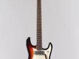 an electric bass guitar hanging from a string on a wall