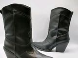 une paire de bottes de cow-boy en cuir noir sur fond blanc