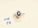 a close up of a ring with a blue stone and diamonds