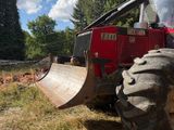 a red tractor that is parked in the grass