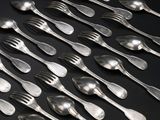 beaucoup de cuillères et de fourchettes en argent sur une table