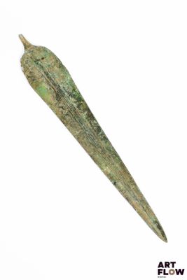 un vieil objet métallique muni d'une longue lame, sur fond blanc