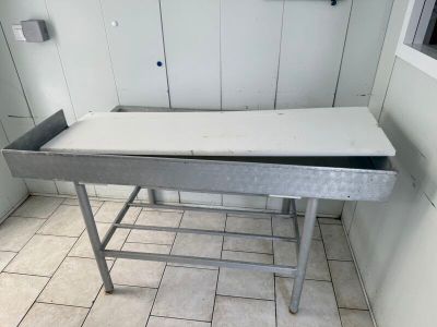 une table en métal avec un tiroir, dans une pièce