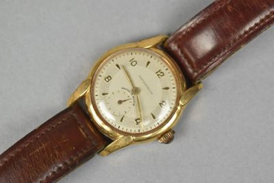 a close up of a wrist watch with a brown strap