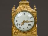 a gold clock sitting on top of a marble table