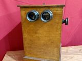 une vieille boîte en bois avec deux yeux, posée sur une table en bois