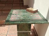 a green marble table with a book on top of it
