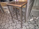 une petite table avec un plateau en bois sur un sol carrelé