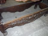 a bed that has a wooden frame with carvings on it