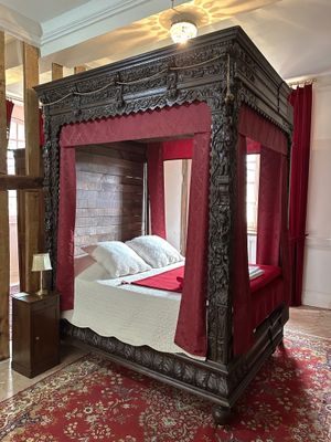 a bed with a red canopy in the middle of a room