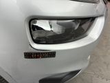 the front end of a white car with a sticker on it ' s bumper