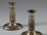 une paire de bougeoirs anciens en argent sur fond gris