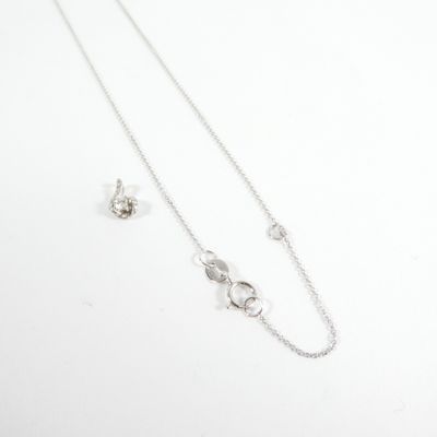 a silver necklace and earring set on a white surface