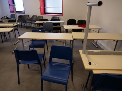 tables and chairs in a room with a red window and a blue chair