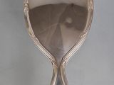 an antique silver plated mirror with a tear shaped handle
