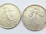 two silver coins, one of which is a woman and one of which is a man