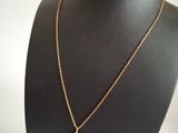 a gold necklace with a coin on a mannequin neck