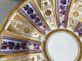 purple and white plate with gold trim and a purple and white plate with a gold rim
