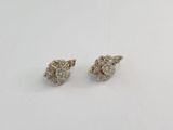 une paire de boucles d'oreilles en diamant sur une surface blanche