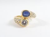 un gros plan d'une bague en or sertie de deux saphirs et de diamants