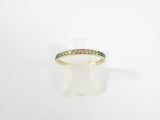 un gros plan d'une bague en or sertie de diamants verts et blancs