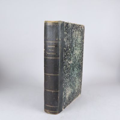 un vieux livre posé sur une table blanche à côté d'un mur blanc