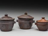 trois casseroles marron avec leurs couvercles sont posées sur une surface blanche