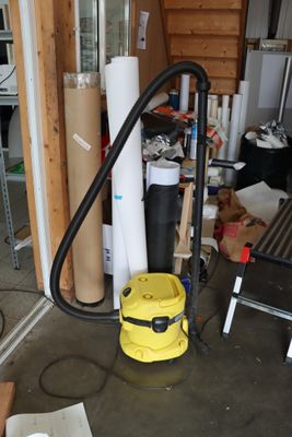 un aspirateur jaune qui est rangé dans un garage